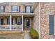 Inviting brick porch with white columns and comfortable seating at 25 Abelia Dr, Covington, GA 30014