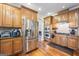 Stainless steel refrigerator and appliances complement this kitchen's wood cabinets and hardwood floors at 25 Abelia Dr, Covington, GA 30014