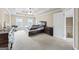 Main bedroom with tray ceiling, carpeted floors, and a stairway door at 25 Abelia Dr, Covington, GA 30014
