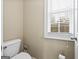 A powder room featuring a commode, toilet paper holder and window at 25 Abelia Dr, Covington, GA 30014