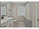 A full bathroom featuring a white vanity with updated fixtures, patterned shower curtain and window at 110 Cloverwood Dr, Fayetteville, GA 30215