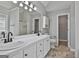 Bright bathroom featuring double sinks, white cabinets, and a large mirror, offering plenty of space at 110 Cloverwood Dr, Fayetteville, GA 30215