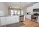 Modern kitchen with white cabinets, granite counters, and stainless steel appliances at 69 Oakhurst Trl, Sharpsburg, GA 30277