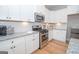 White kitchen with stainless steel appliances and granite countertops at 69 Oakhurst Trl, Sharpsburg, GA 30277