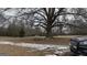 Large yard with mature trees and light dusting of snow at 1597 Highway 92 S, Fayetteville, GA 30215