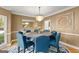 Formal dining room with round table, blue chairs, and chandelier at 150 S Kite Lake Rd, Fayetteville, GA 30214