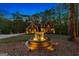 Evening view of home's front yard, featuring a fountain and landscaping at 150 S Kite Lake Rd, Fayetteville, GA 30214
