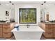 Elegant bathroom featuring a soaking tub, dual vanities, and a large window overlooking a wooded view at 200 Simonton Rd, Lawrenceville, GA 30046