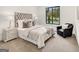 Elegant bedroom features a tufted headboard, plush bedding, accent chair, and large window with natural light at 200 Simonton Rd, Lawrenceville, GA 30046