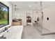 Modern bathroom featuring a soaking tub, glass shower, and view to bedroom at 200 Simonton Rd, Lawrenceville, GA 30046