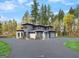 A modern home surrounded by mature trees and a driveway leading to a spacious three-car garage at 200 Simonton Rd, Lawrenceville, GA 30046