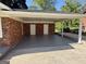 Spacious carport area with a smooth concrete floor and two white entry doors at 6148 Park Dr, Forest Park, GA 30297