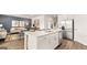 Modern kitchen with island and stainless steel appliances, open to living area at 749 Myrica Ave # 208, Locust Grove, GA 30248