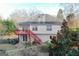 View of the home's backyard with a deck and stairs, plus mature trees at 402 Stonebrooke Dr, Auburn, GA 30011