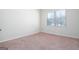 Bright bedroom featuring neutral walls and carpeting, plus a large window at 160 Traditions Ln, Hampton, GA 30228