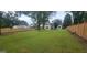 Spacious fenced backyard with a well-manicured lawn and mature trees at 213 W Hightower Trl, Social Circle, GA 30025