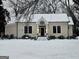 Snowy landscape showcases the charming home's inviting entrance with classic details at 213 W Hightower Trl, Social Circle, GA 30025