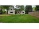 View of a home's exterior with a large front lawn and mature shade trees at 213 W Hightower Trl, Social Circle, GA 30025