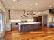 Open kitchen with a large center island, stainless appliances, and beautiful hardwood floors at 213 W Hightower Trl, Social Circle, GA 30025