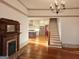 A spacious living room with a decorative fireplace, staircase, and view of the updated kitchen at 213 W Hightower Trl, Social Circle, GA 30025