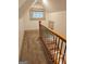 Staircase landing with carpet, stained glass window, and wooden railing at 213 W Hightower Trl, Social Circle, GA 30025