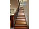 Staircase with wood treads, white risers, decorative iron railing, and views into the modern kitchen at 213 W Hightower Trl, Social Circle, GA 30025