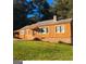 Charming home with vibrant orange siding, stone foundation and inviting front porch at 5094 Covington Hwy, Decatur, GA 30035
