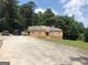 Ranch style home with a long driveway and mature trees at 5094 Covington Hwy, Decatur, GA 30035