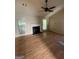 Cozy living room featuring a fireplace, ceiling fan, and wood-look laminate flooring at 7166 Thunder Rdg, Jonesboro, GA 30236