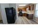 Galley kitchen with wood cabinets, black appliances, and light gray vinyl flooring at 6627 Coventry Pt, Austell, GA 30168