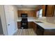 Kitchen features wood cabinets, black appliances, and vinyl flooring at 6627 Coventry Pt, Austell, GA 30168