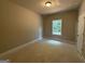 Sunlit bedroom featuring a window with outdoor views and neutral walls at 142 Asa Moseley Rd, Mcdonough, GA 30252