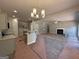 Open-concept living area featuring a cozy fireplace, a decorative light fixture, and seamless flow to the kitchen at 142 Asa Moseley Rd, Mcdonough, GA 30252
