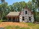 New construction home with a covered front porch, surrounded by mature trees at 150 Asa Moseley Rd, Mcdonough, GA 30252