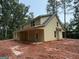 Two-story home with light yellow siding and a covered porch overlooking a wooded landscape at 150 Asa Moseley Rd, Mcdonough, GA 30252