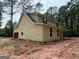 Two-story home with light yellow siding and a covered porch in a wooded setting at 150 Asa Moseley Rd, Mcdonough, GA 30252