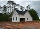 Side view of new home featuring an attached garage and white siding against a green backdrop at 136 Asa Moseley Rd, Mcdonough, GA 30252