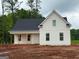 New construction home with white siding, black roof, and inviting front porch, ready for landscaping at 136 Asa Moseley Rd, Mcdonough, GA 30252