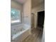 Bright bathroom showcasing a soaking tub, glass-enclosed shower, and closet at 148 Asa Moseley Rd, Mcdonough, GA 30252