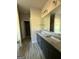 Bathroom featuring double vanity with granite countertop, framed mirror, and open doorway at 148 Asa Moseley Rd, Mcdonough, GA 30252