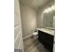Powder room features granite counters, a dark vanity, mirror, new floors and modern fixtures at 148 Asa Moseley Rd, Mcdonough, GA 30252