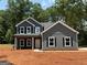 New construction features a gray exterior, black shutters, covered porch, and professional trim work at 148 Asa Moseley Rd, Mcdonough, GA 30252