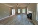Open living room features new floors, a ceiling fan, a fireplace and large windows overlooking the yard at 148 Asa Moseley Rd, Mcdonough, GA 30252