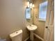 Small bathroom with pedestal sink, toilet, and oval mirror at 270 Marriott Dr, South Fulton, GA 30349