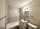 Updated bathroom with marble tile and granite vanity at 3961 Cornell Sw Blvd, Atlanta, GA 30331