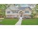 Two-story house with brick and siding exterior, landscaped lawn, and walkway at 1134 Wagon Trce, Douglasville, GA 30134