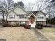 Two-story house with brick and siding exterior, landscaped lawn, and walkway, red front door at 1134 Wagon Trce, Douglasville, GA 30134