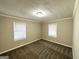 Cozy bedroom with neutral carpeting and two windows at 6419 Katherine St, Douglasville, GA 30134