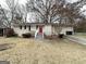 Brick ranch home with a red door, landscaping, and a driveway at 6419 Katherine St, Douglasville, GA 30134