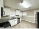 Updated kitchen with white cabinets, granite counters, and stainless steel appliances at 6419 Katherine St, Douglasville, GA 30134